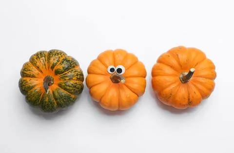 Three pumpkins on white background with creative faces Stock Photos