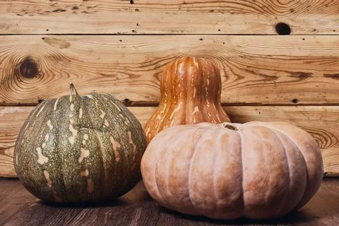 Three pumpkins on wooden table Stock Photos