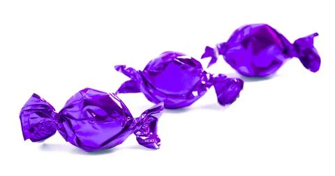 Three Purple Wrapped Candy Isolated on a White Background Stock Photos