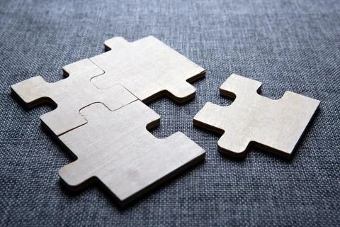 Three puzzle pieces in a row on a textile background Stock Photos