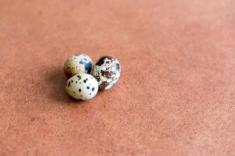 Three quail eggs on a brown background Foto stock