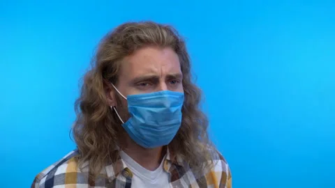 Three-quarter portrait. long-haired man coughs. big infectious man in a medical Stock Footage 138029611