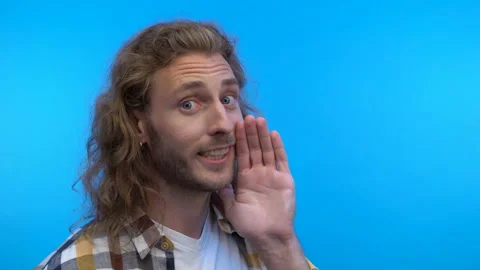 Three-quarter portrait.long-haired curly man on an isolated blue background. Man Stock Footage 138031438