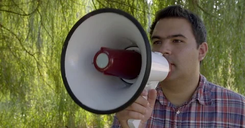Three quarter view of man using megaphone in outdoor setting 4K Stock Footage 80933997