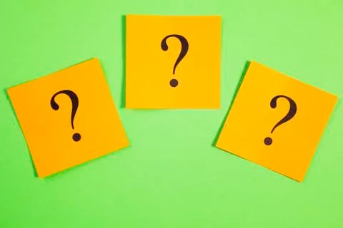 Three question marks orange on green background Stock Photos