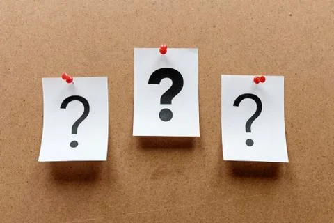 Three question marks pinned to a notice board Foto stock