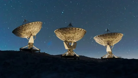 Three radio telescopes tracking under a starry night sky Stockbeeldmateriaal 201100528