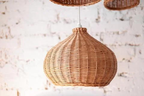 Three rattan chandeliers different forms on white brick wall background. Stra Stock Photos