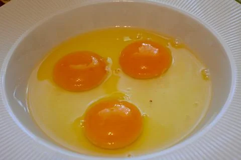 Three raw eggs in a bowl 스톡 사진