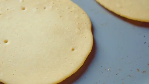 Three raw flapjack, tortilla, pancakes, bake fry in pan. Cooking. Close up. Stock Footage 128701601