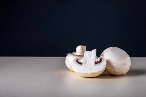 Three raw fresh champignons on table Stock Photos