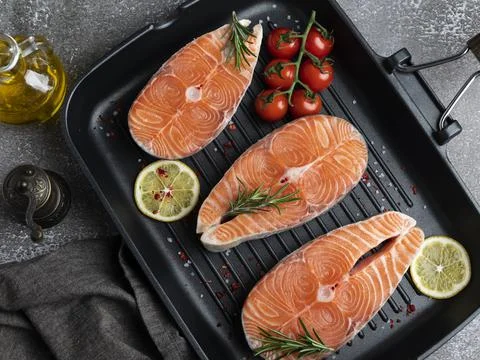 Three raw fresh steak fish trout, salmon and spices on grill pan, Stock Photos