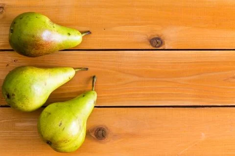 Three raw green pears on table wooden table Stock Photos