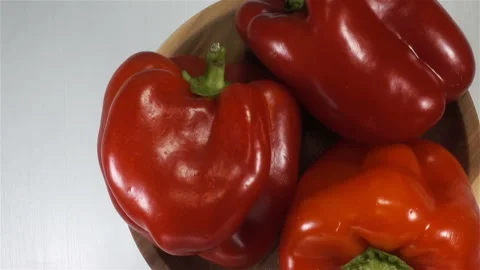 Three raw red bell peppers close-up Stock Footage 139738540