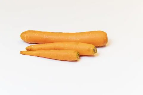 Three raw uncleaned carrots on white background Stock Photos