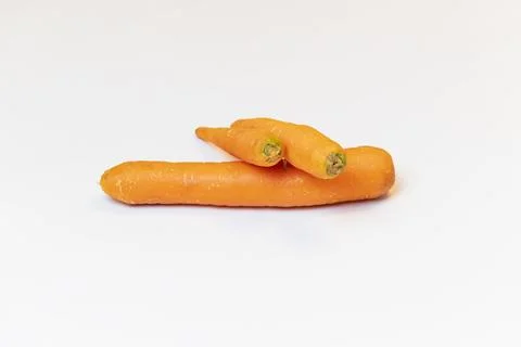 Three raw uncleaned carrots on white background Foto stock
