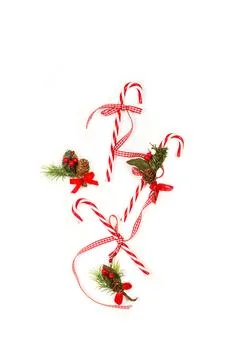 Three red and white candy canes and christmas ornaments Stock Photos