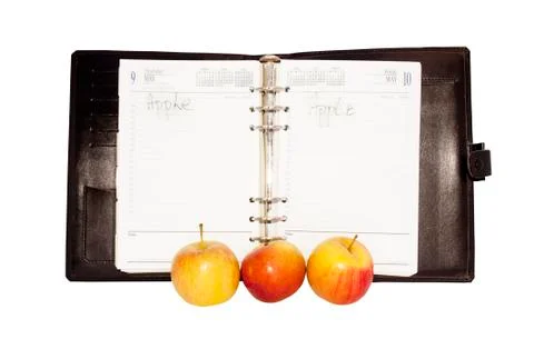 Three red and yellow apples with an open diary Stock Photos