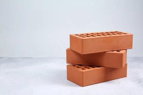 Three red bricks on textured table against light background, space for text.. Stock Photos