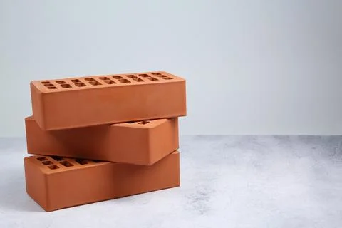 Three red bricks on textured table against light background, space for text.. Stock Photos