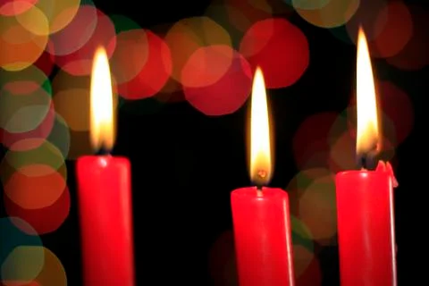 Three red candles on the background of colored balls Stock Photos