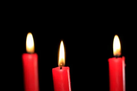 Three red candles on a black background Stock Photos