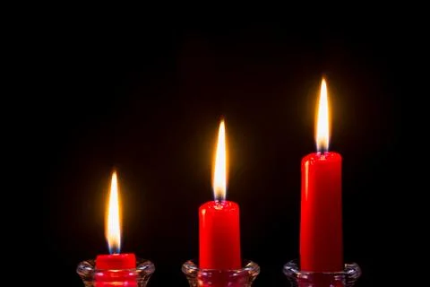 Three red candles on a black background Stock Photos