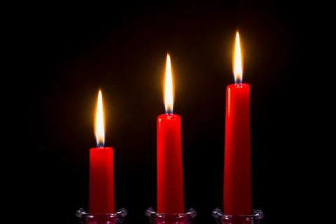 Three red candles on a black background Stock Photos