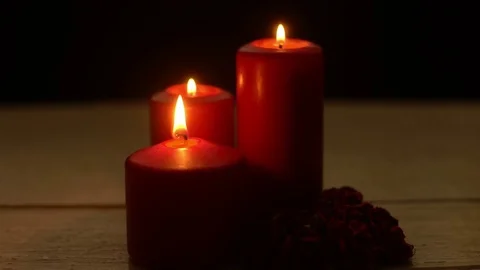 Three red candles burn and roses in romantic time on wood table Stock Footage 79808241