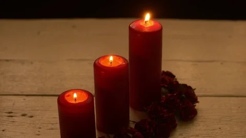 Three red candles light with rose on white table Stock Footage 78999024