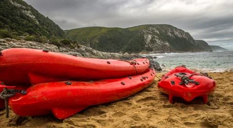 Three red canoes on the beach Stock Photos