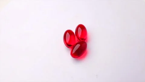 Three red capsules on a white background, rotation in circle. Stock Footage 277277321
