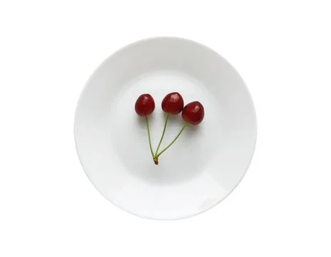Three red cherries on a white round plate isolated on a white background Stock Photos