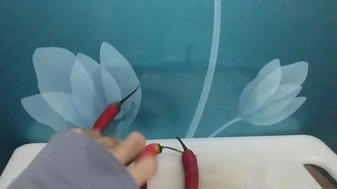 Three Red Chili Peppers on the Table, One Taken Away Stock Footage 229305879