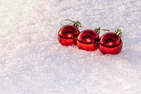 Three red christmas tree balls on white snow Stock Photos