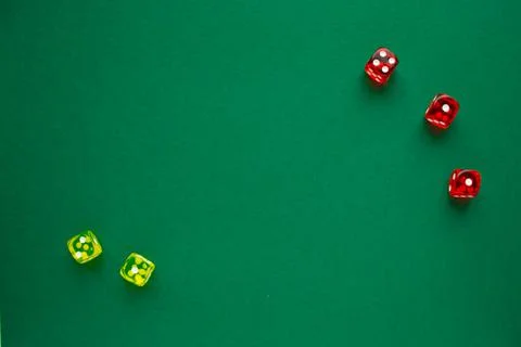 Three red dices and two yellow dices on green background Stock Photos