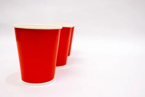 Three red disposable cups lined up against a plain white background with co.. Stock Photos
