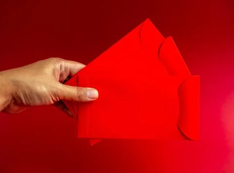 Three red envelope holding by hand isolated on red background. 3 Hongbao pa.. Stock Photos