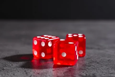 Three red game dices on grey textured table, closeup. Space for text Stock Photos