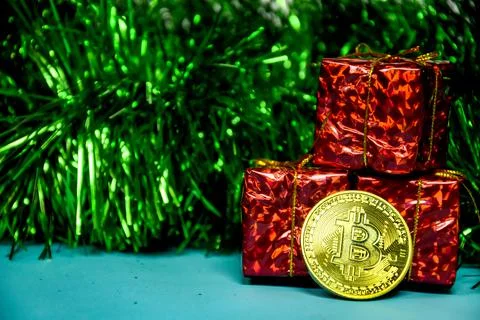 Three red gift boxes and a gold bitcoin coin are placed against the background Stock Photos