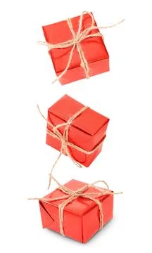 Three red gift boxes wrapped with rustic twine and bows, floating or fallin.. Stock Photos