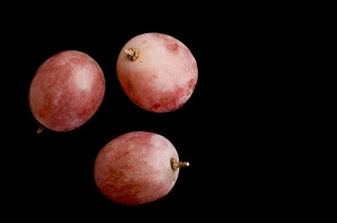 Three red grapes isolated on black background Foto stock