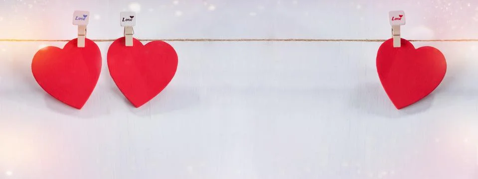 Three red hearts set on string over white background. Stock Photos