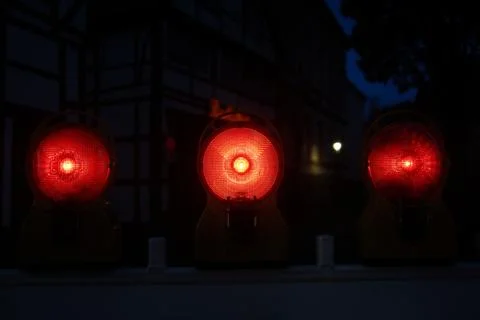 Three red lights are lit up in the dark Stock Photos
