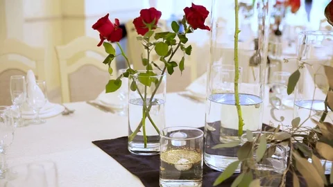 Three red lush roses in a vase on the table in a restaurant. Stock Footage 116975566