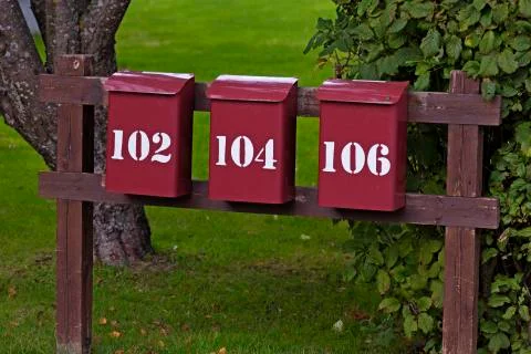 Three red mailboxes in a row with white text on Roback Stock Photos