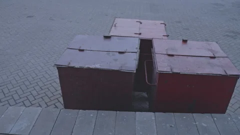 Three red metal dumpsters standing partially open Stock Footage 295953695