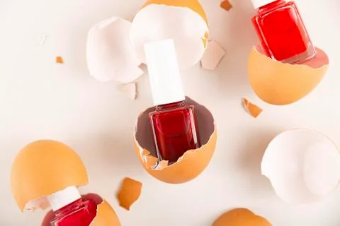 Three red nail polishes in eggshell on light background Stock Photos