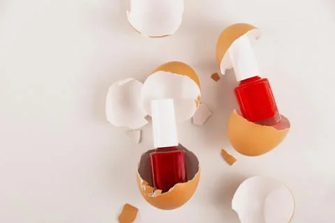 Three red nail polishes in eggshell on light background Stock Photos