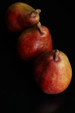 Three red pears on a black table Foto stock